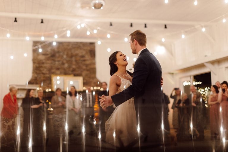 lauren+samuel dance under the lights during their wedding at The Farm in Candler, NC