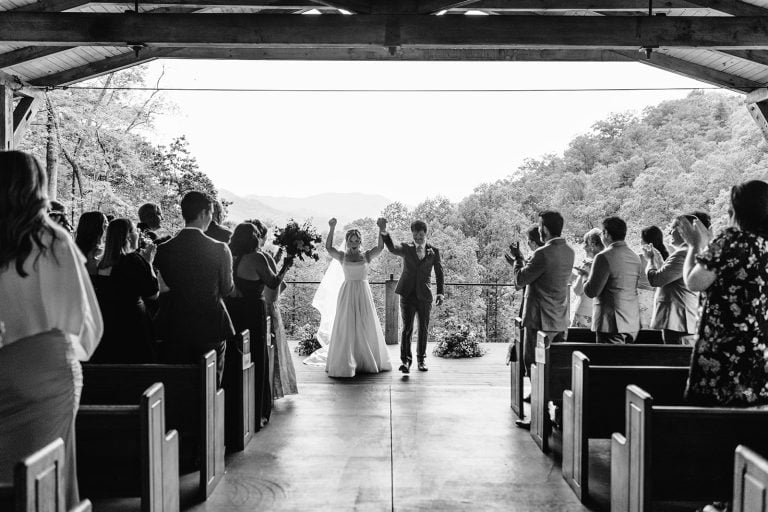 Piper and Ean celebrate as they walk down the aisle during their wedding in Whitier NC